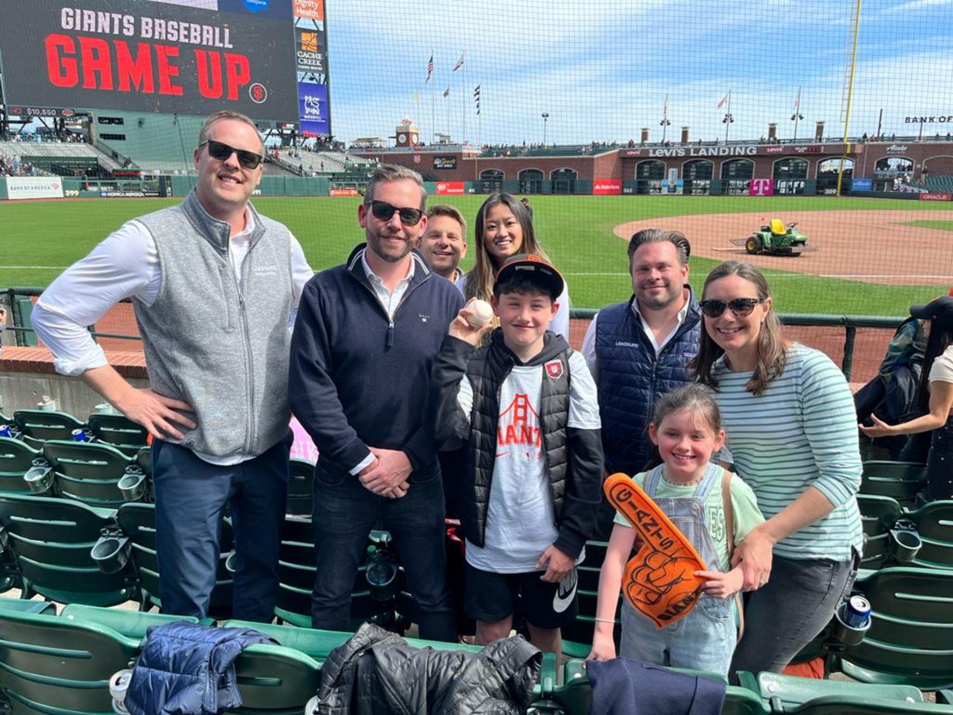 A group shot of some of the Loadsure team and their kids at a baseball game.