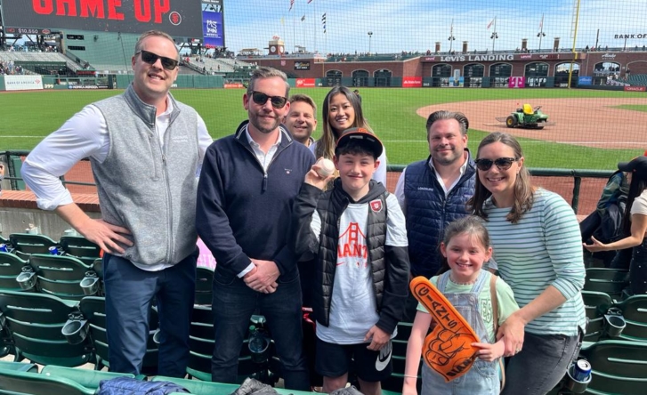A group shot of some of the Loadsure team and their kids at a baseball game.